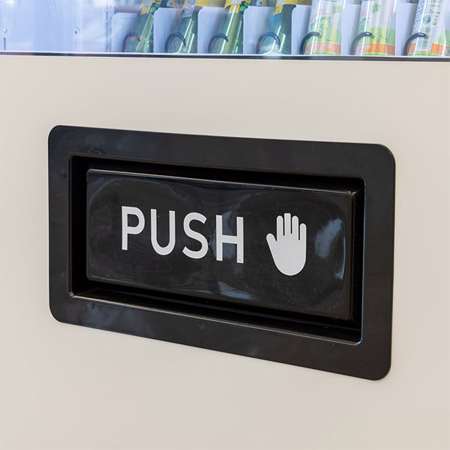 Close-up of DV5000C10 combo vending machine push delivery port with 'PUSH' label and hand icon