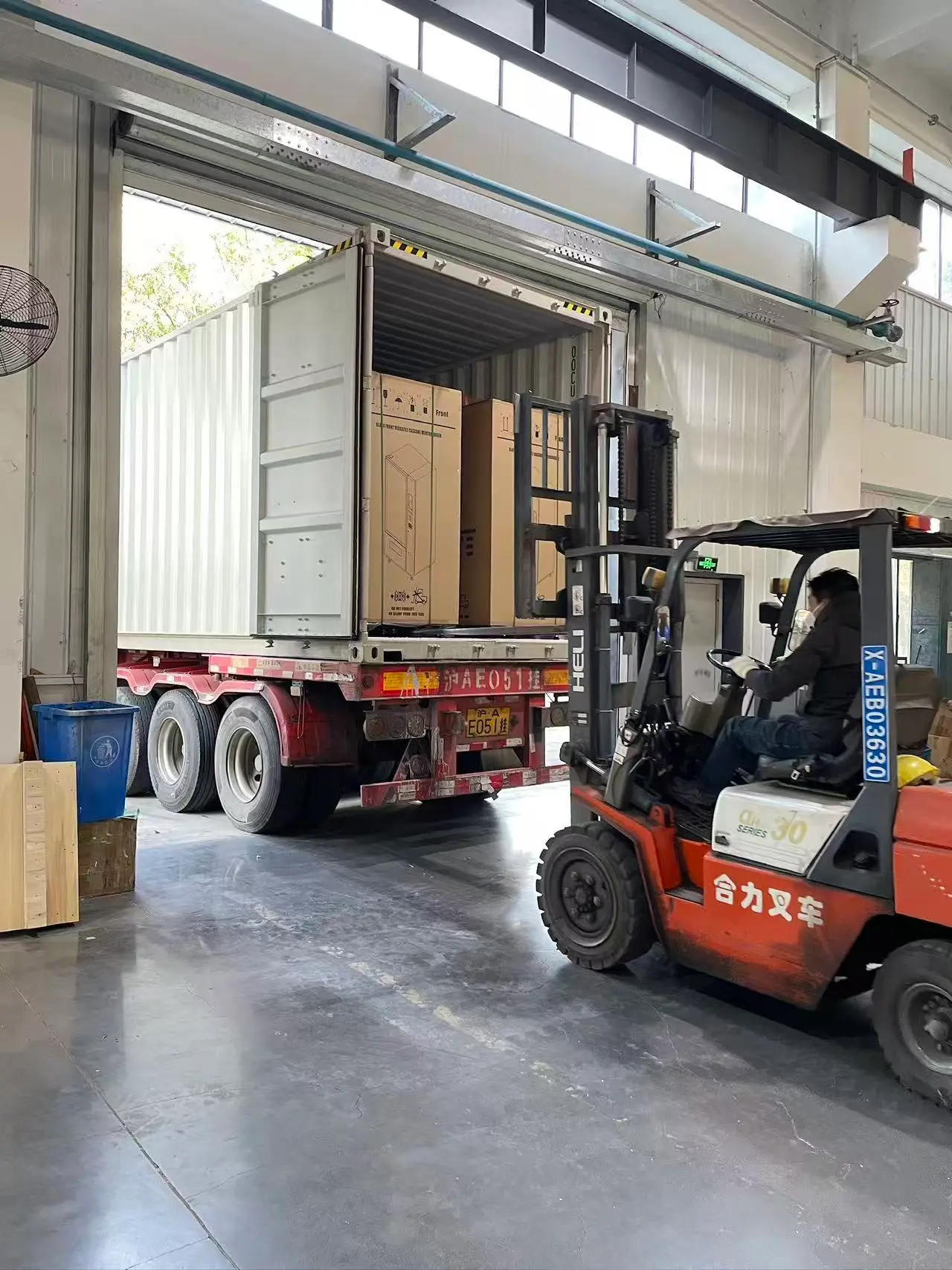 Forklift loading vending machine cartons into a shipping container for export